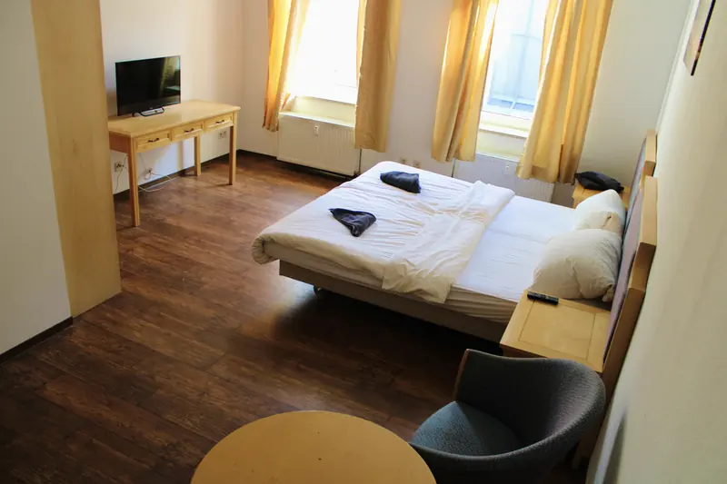 Zimmer mit Fernseher und Arbeitsplatz
