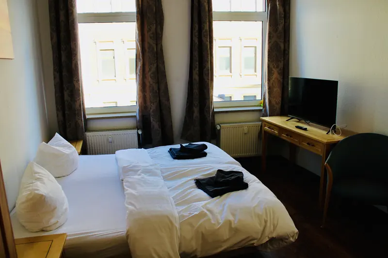 Zimmer mit Fernseher und großen Fenstern